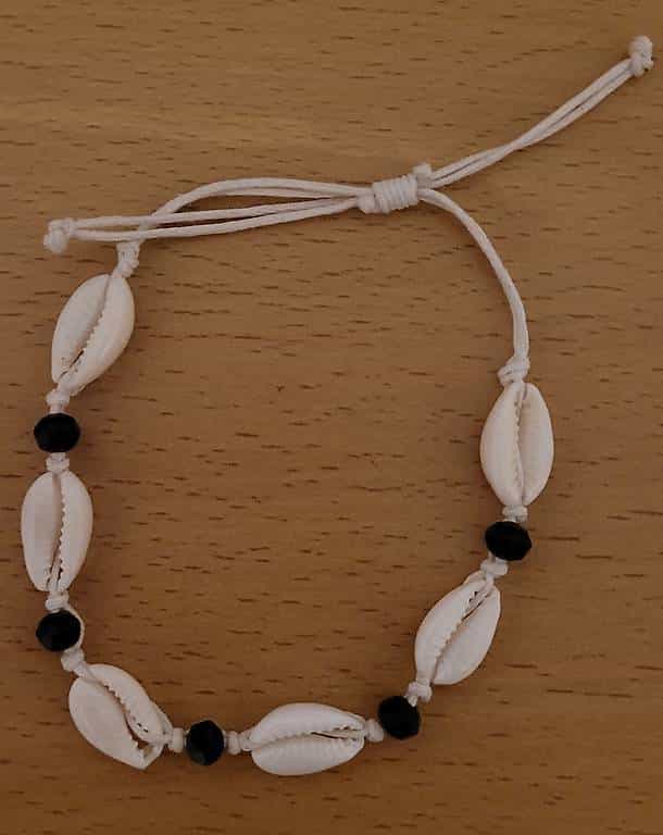 einem Armband mit Kauri- oder Buzios-Muscheln