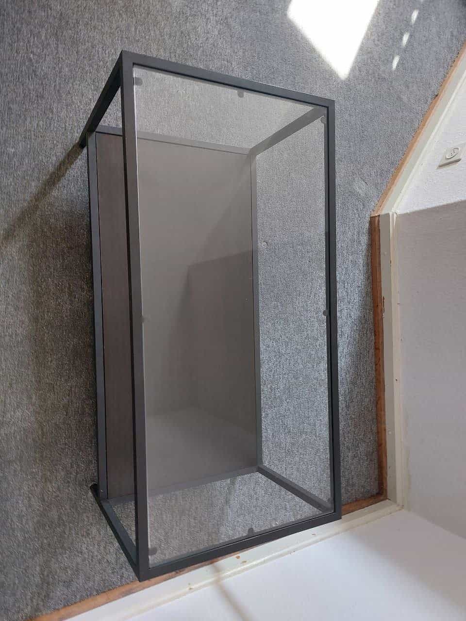 Wandvitrine mit Glasfront, schwarzer Metallrahmen