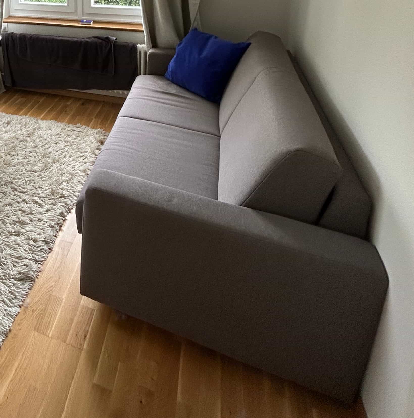 Schlafsofa grau mit blauen Kissen