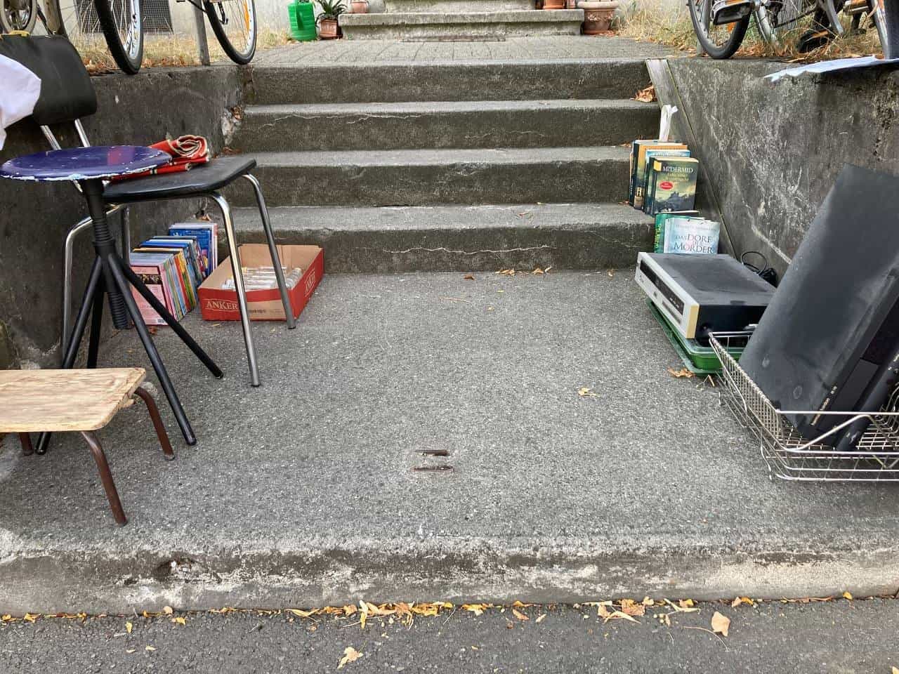 Verschiedene Gegenstände: CD-Player, Bücher, Stühle, DVDs
