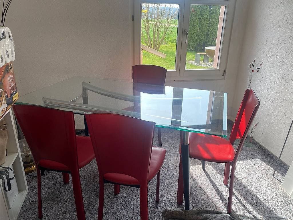 Glastisch mit 4 roten Stühlen