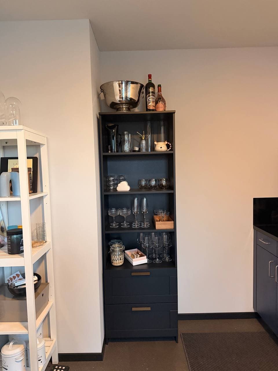 Schwarzer Schrank mit Gläsern und Dekoration