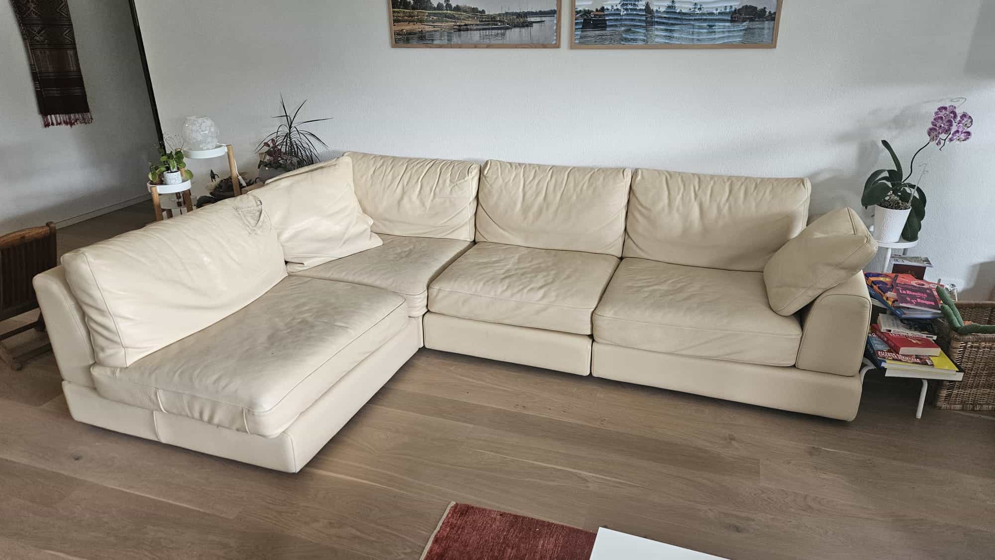 Canapé d angle en cuir clair dont les parties sont modulables.